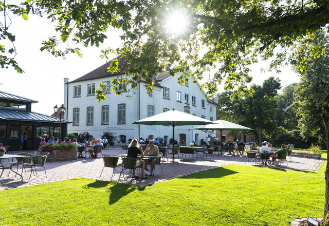 Gäste genießen Speisen auf der Terrasse des Gut Kaden Restaurants